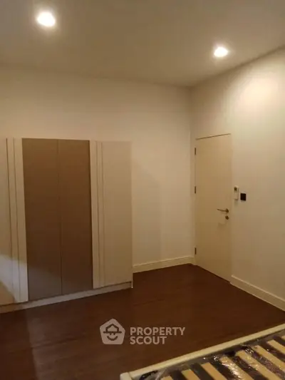 Spacious bedroom with modern wardrobe and wooden flooring