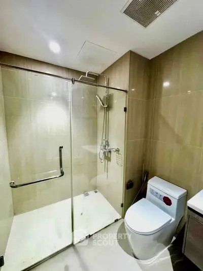 Modern bathroom with glass shower enclosure and sleek fixtures
