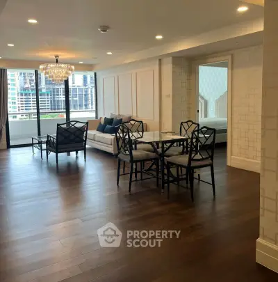 Spacious modern living room with elegant dining area and city view, featuring hardwood floors and chic chandelier.