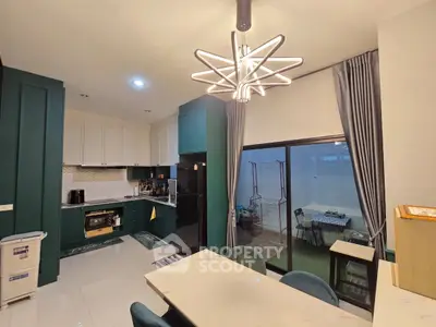 Modern kitchen with stylish lighting and open layout leading to a cozy balcony.