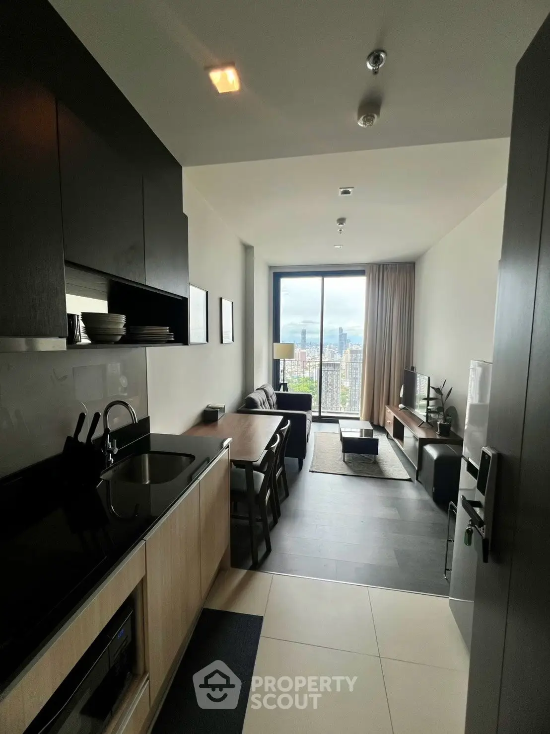 Modern apartment with open kitchen and stunning city view from living room.