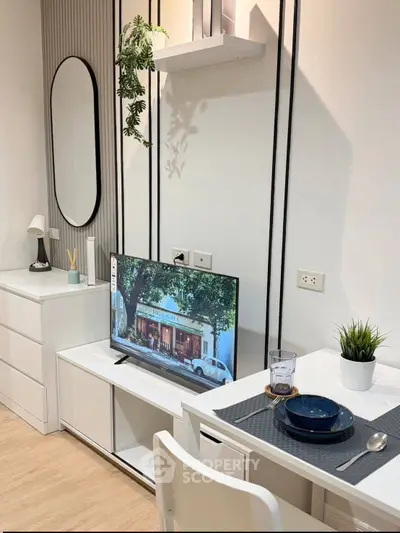 Modern living room with sleek furniture and stylish decor, featuring a wall-mounted TV and dining area.
