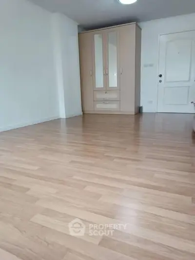 Spacious empty room with wooden flooring and built-in wardrobe, ideal for customization.