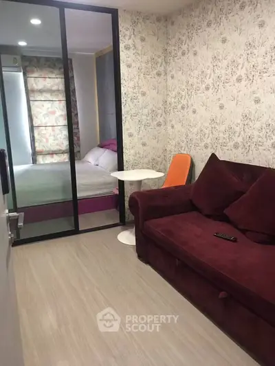 Cozy living room with modern decor and sliding glass doors leading to a bedroom.