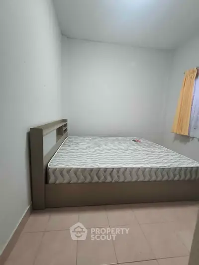 Cozy bedroom with minimalist design featuring a comfortable bed and soft lighting.