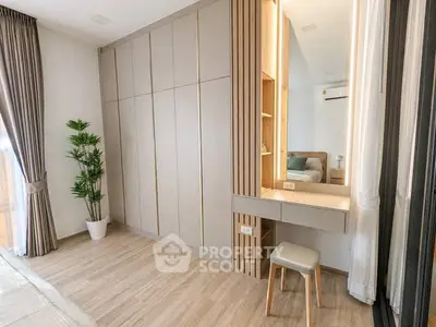 Modern bedroom with built-in wardrobe and stylish vanity in bright, airy space.