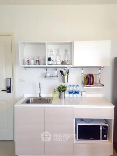 Modern compact kitchen with sleek cabinetry and built-in microwave