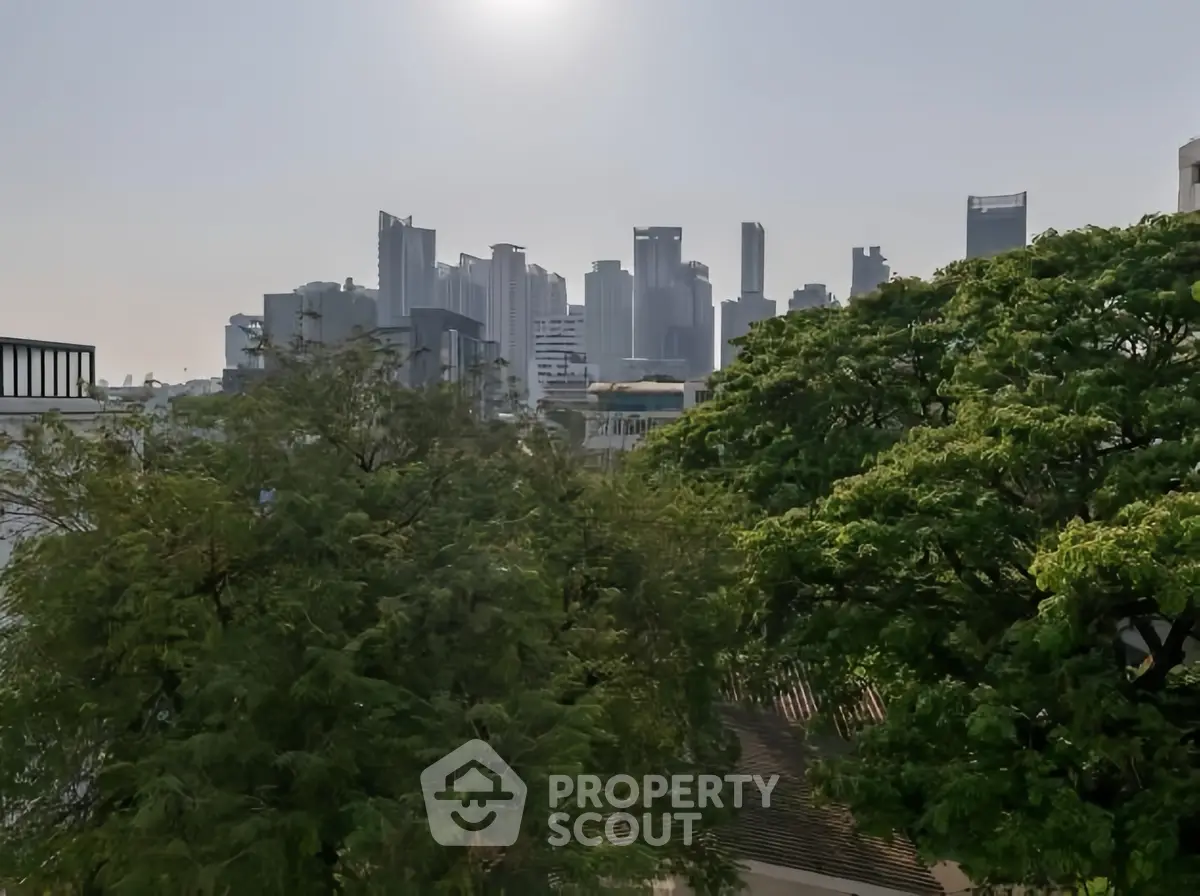 Stunning city skyline view with lush greenery in the foreground, perfect for urban living enthusiasts.