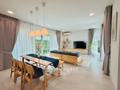 Spacious modern living room with elegant dining area and large windows.