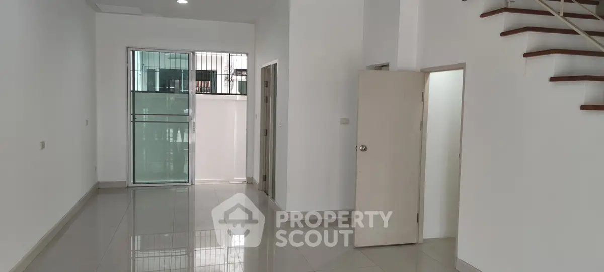Spacious modern interior with sleek staircase and large windows, perfect for urban living.