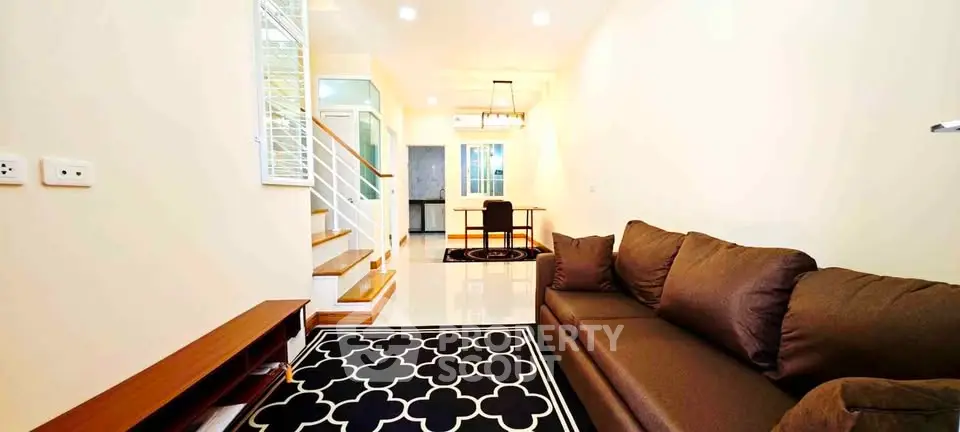 Modern living room with stylish decor and staircase in a cozy home setting.