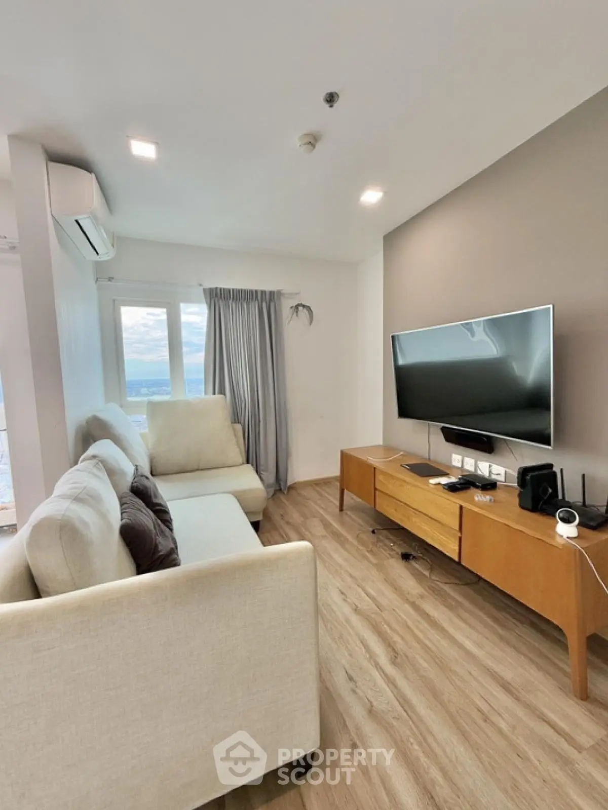 Modern living room with sleek design and large window offering a stunning view.