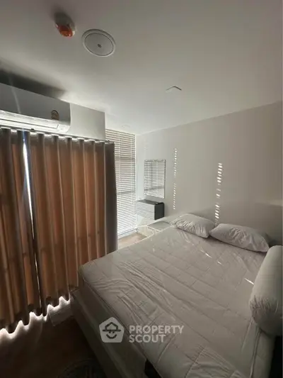 Cozy bedroom with modern air conditioning and natural light filtering through blinds.