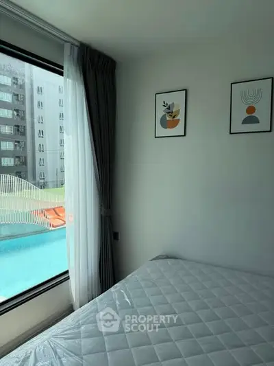 Modern bedroom with pool view, large window, and stylish decor.