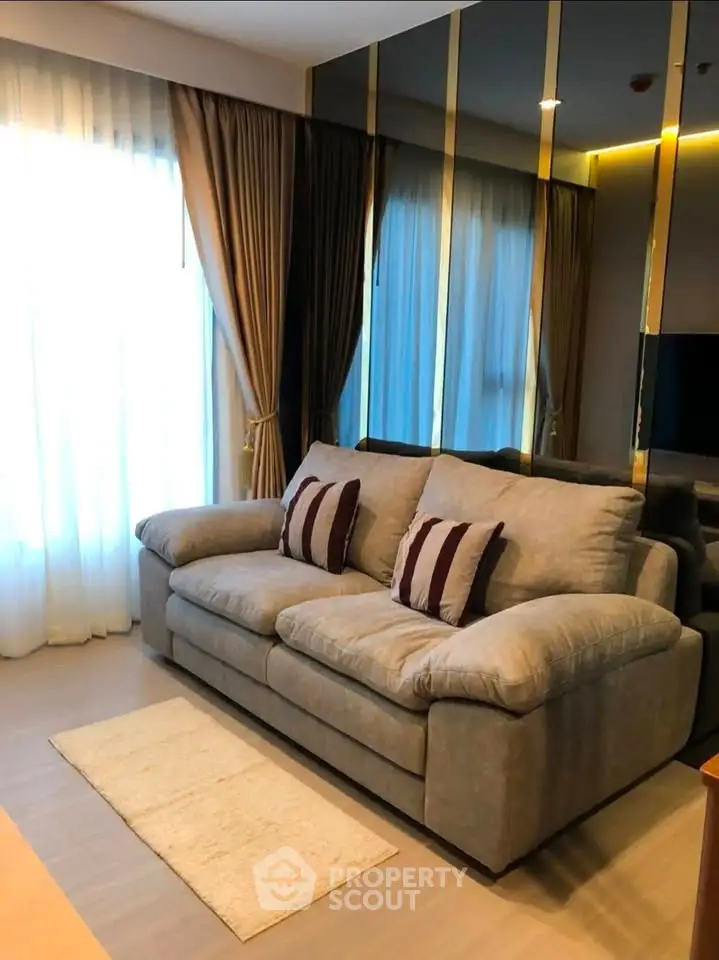 Cozy living room with plush sofa and elegant curtains in modern apartment.