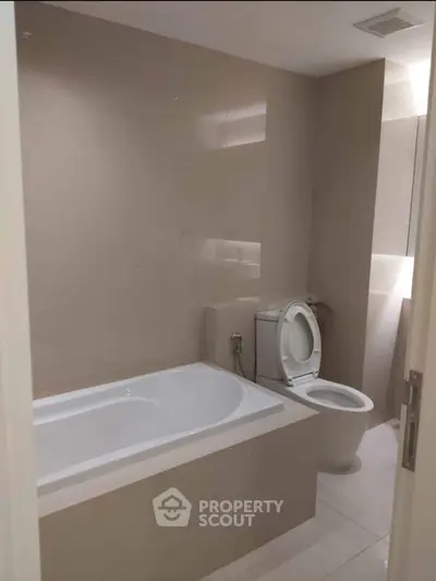Modern bathroom with sleek design and bathtub in contemporary apartment.