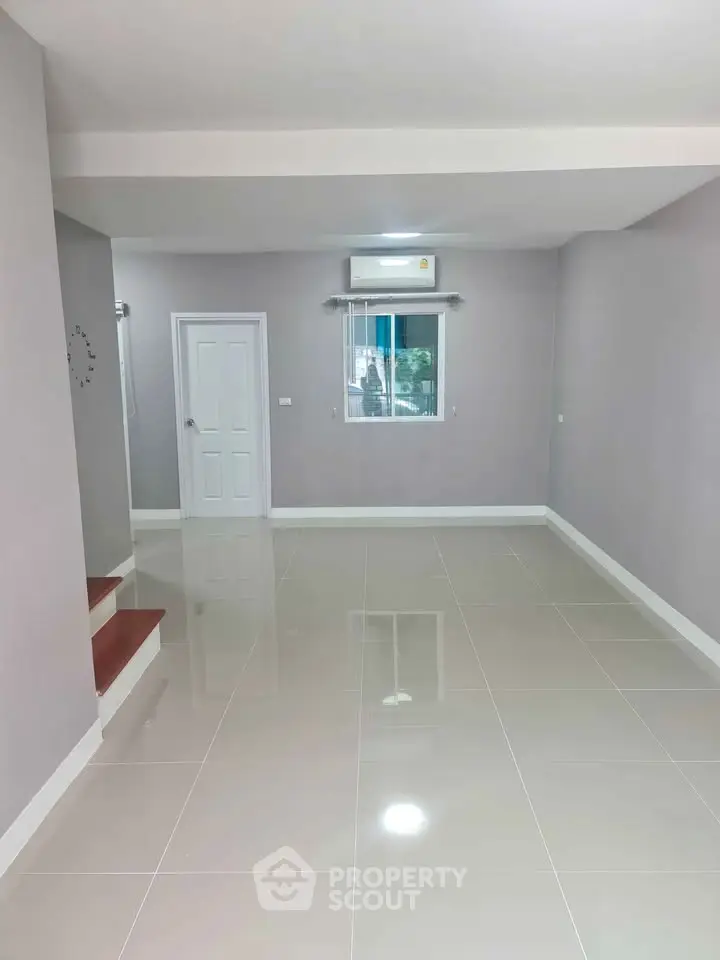 Spacious empty room with glossy tiled floor and air conditioning