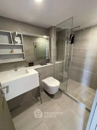 Modern bathroom with sleek design, featuring a glass shower enclosure and contemporary fixtures.