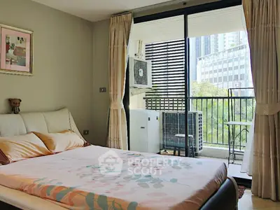 Modern bedroom with balcony view in urban apartment, featuring stylish decor and natural light.