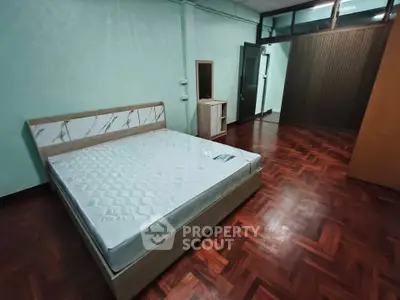 Spacious bedroom with wooden flooring and modern bed frame