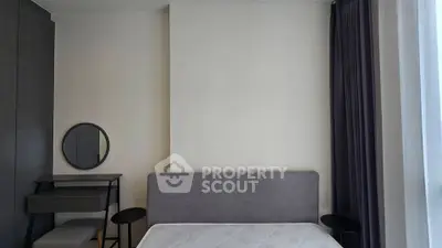 Modern bedroom with minimalist design featuring a bed, side tables, and a vanity with a round mirror.