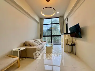 Modern living room with large window and stylish furniture, perfect for relaxation and entertainment.