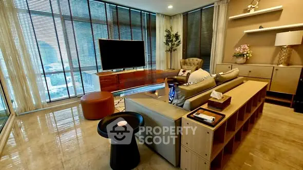 Luxurious living room with modern decor and large windows offering stunning city views.