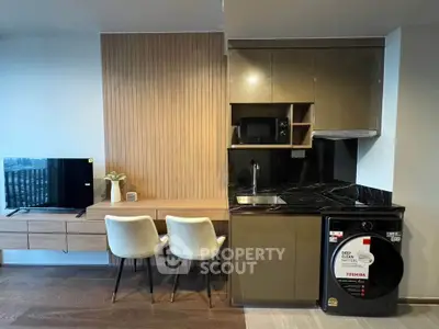 Modern studio apartment with sleek kitchen and cozy dining area