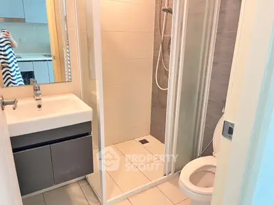 Modern bathroom with shower and sleek vanity in a contemporary apartment.