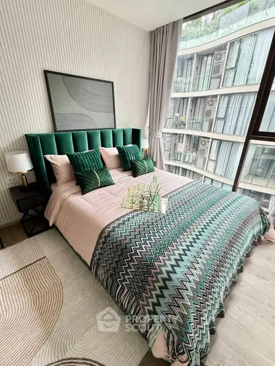 Luxurious bedroom with modern decor and large window offering stunning city views.