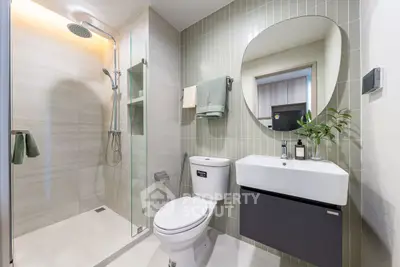 Modern bathroom with glass shower and sleek fixtures in contemporary home.