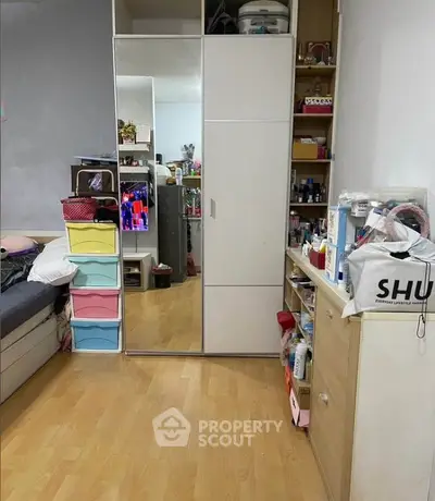 Cozy bedroom with mirrored wardrobe and colorful storage drawers