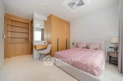 Modern bedroom with stylish decor and built-in storage, featuring a cozy bed and elegant lighting.