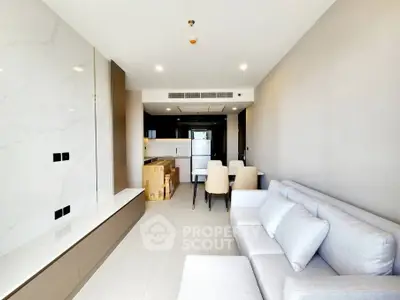 Modern living room with sleek design and open kitchen layout in a contemporary apartment.