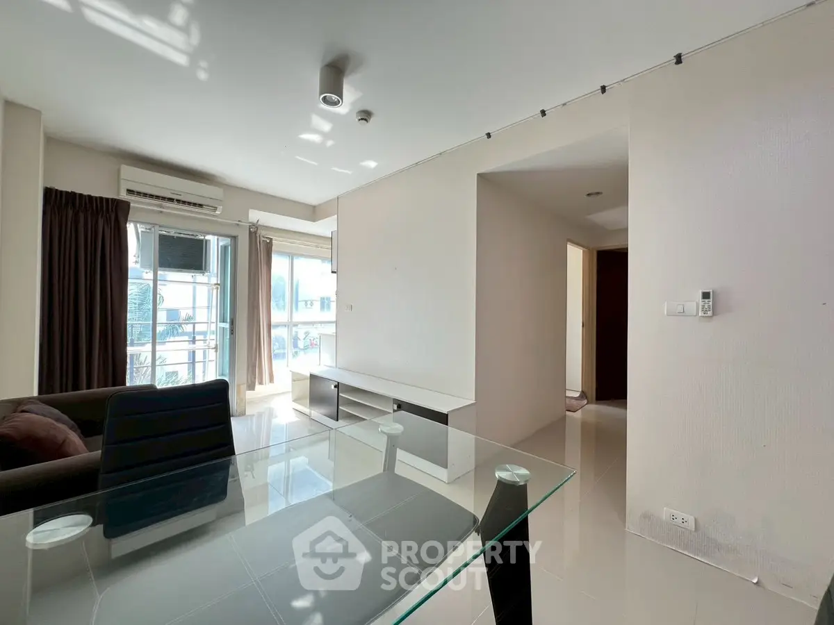 Modern living room with glass table and natural light in urban apartment