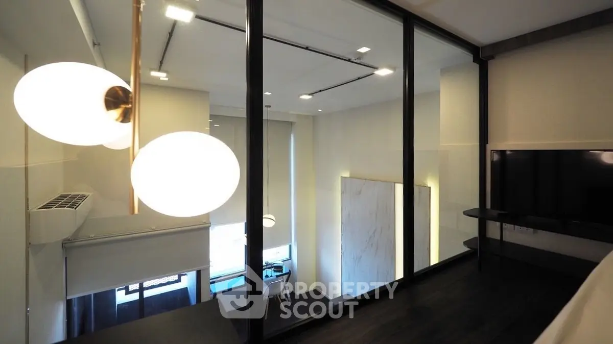 Modern interior with glass partition and stylish lighting in a contemporary apartment.