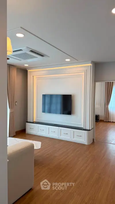 Elegant living room with modern TV setup and stylish wooden flooring