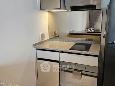 Modern kitchen with sleek design, featuring built-in oven and electric cooktop.
