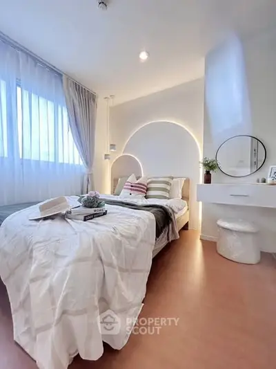 Modern bedroom with stylish decor and natural light, featuring a cozy bed and elegant furnishings.
