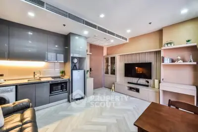Modern open-layout kitchen and living room with sleek cabinetry and cozy seating area.