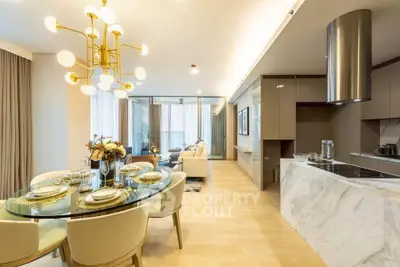Luxurious open-plan living and dining area with elegant lighting and modern kitchen design.
