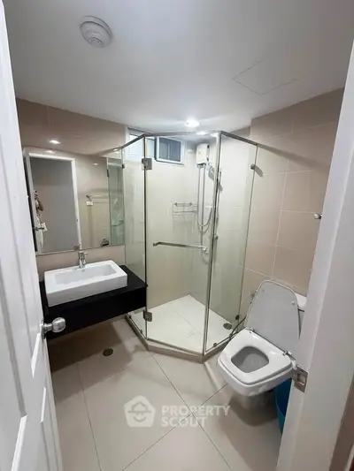 Modern bathroom with glass shower enclosure and sleek fixtures