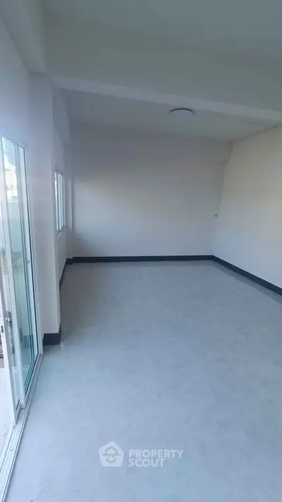 Spacious empty room with large windows and sliding glass door