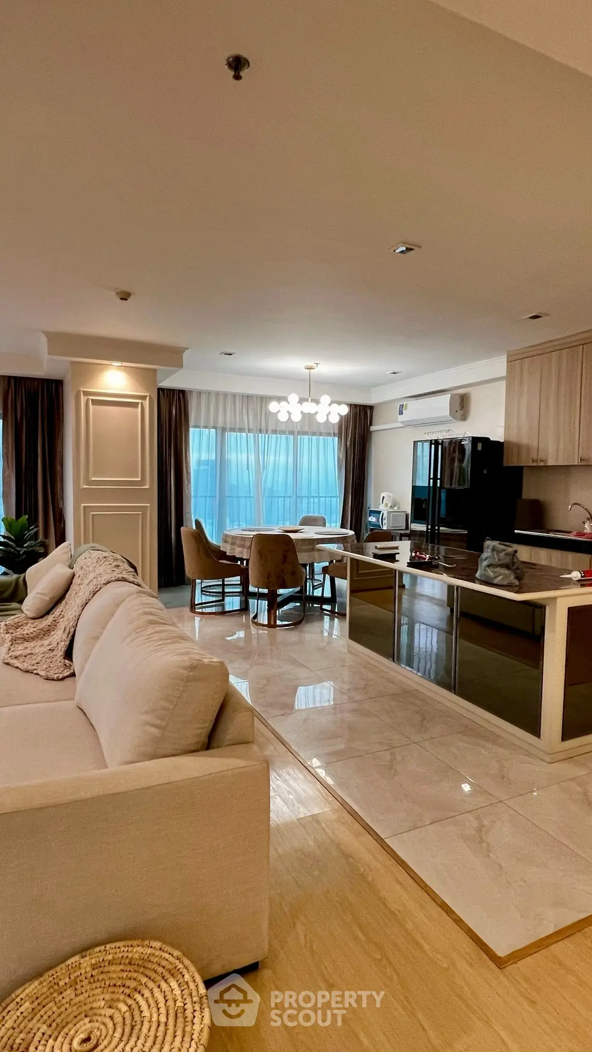 Spacious open-layout living room with modern kitchen and elegant dining area.