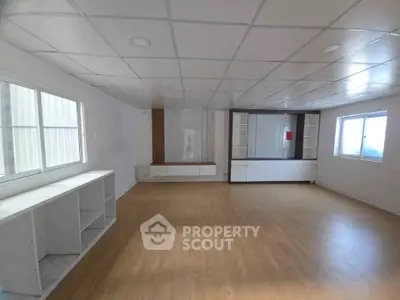Spacious unfurnished room with wooden flooring and built-in shelves, ideal for customization.