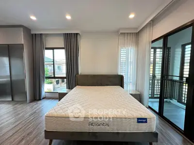 Spacious bedroom with large windows and balcony access in modern home