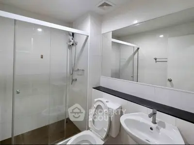 Modern bathroom with glass shower and sleek fixtures in a contemporary home.