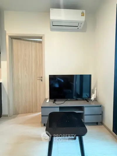 Modern living room with sleek TV setup and air conditioning, perfect for cozy relaxation.