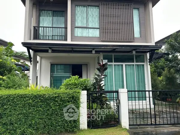 Modern two-story house with lush garden and large windows