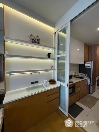 Modern kitchen with sleek wooden cabinets and built-in appliances in a stylish apartment.